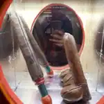 Art installation with leather and rubber items in a mirror display.